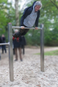 s'entraîne sur le playfit Barre fixe 3 positions K05001 dans un parc avec sol sablonneux