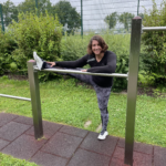 s'entraîne sur le playfit Barres parallèles inclusives K05004 dans un parc avec dalles amortissantes