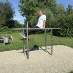 trainiert am playfit Barren K05005 im Park mit Kiesfläche