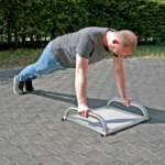 zeigt eine Übung am playfit Handstand-Liegestütz-Trainer K05008