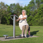 si allena sul playfit Allenatore dorsale K05011 in un area verde nel parco