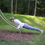 nutzt den playfit Armzug-Liegestütz-Trainer K05014 im Outdoor-Fitnesspark