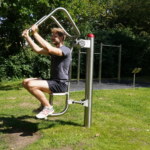 nutzt den playfit Oberkörpertrainer - Pressen K05029 im Outdoor-Fitnesspark