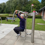 playfit Oberkörpertrainer - Pressen K05029 – Seitenansicht im Park mit Rasenfläche