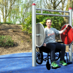 beim Armtraining im Rollstuhl am playfit Rollstuhltrainer K05036 im Freien
