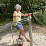 trainiert am playfit Gleichgewichtstrainer K05038 im Fitnesspark mit Tartanbelag