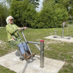 s'entraîne sur le playfit Rider K05040 dans un terrasse avec sol en bois
